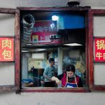 Una-mujer-vista-a-través-de-la-ventana-cocina-en-un-restaurante-callejero_-en-Pekín